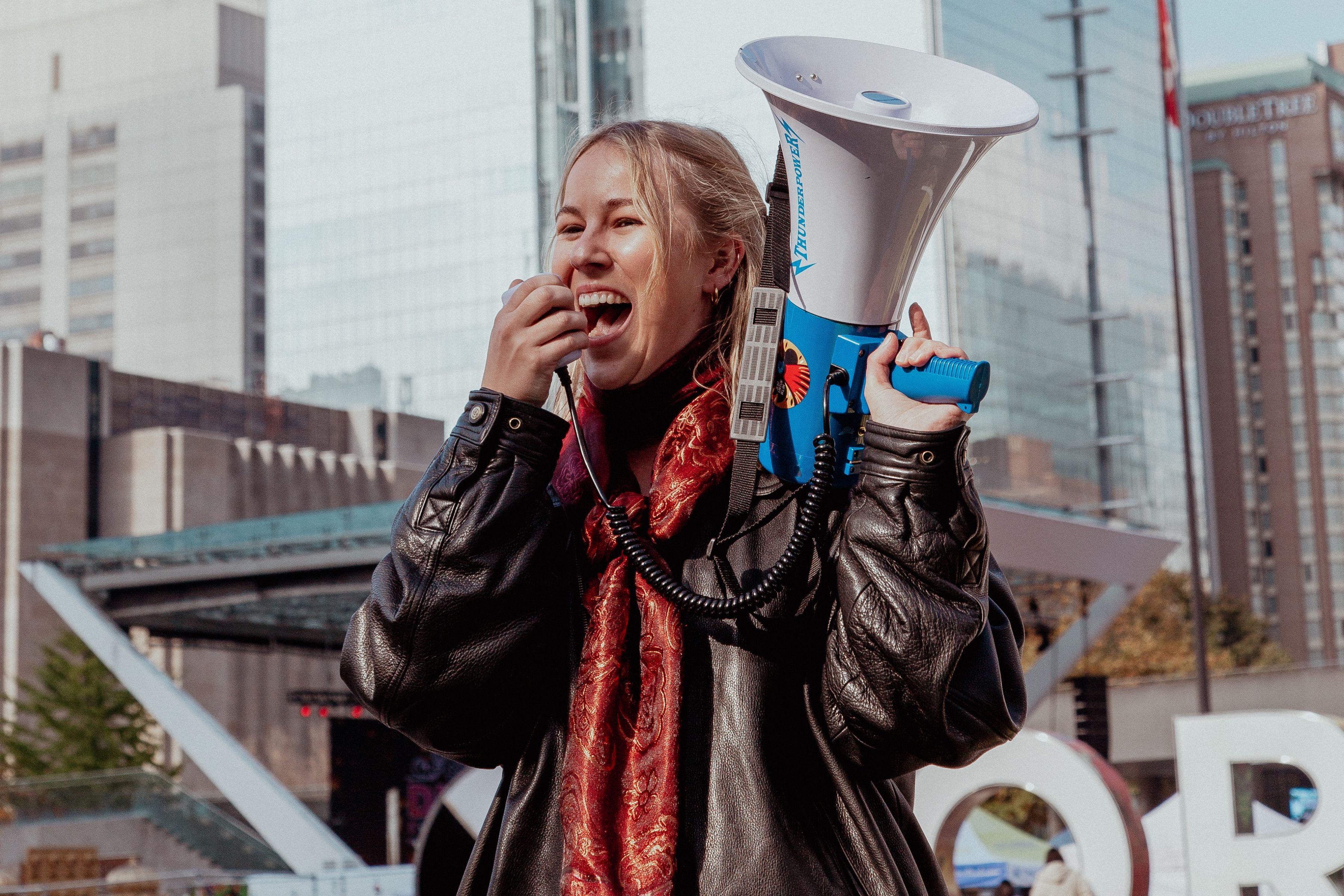 Climate protest with people holding signs including 'NO MORE FOSSILS' and 'FUND CLIMATE'